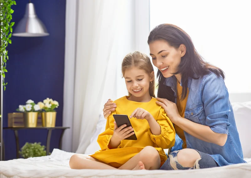 Happy Mother and Daughter Holding Phone